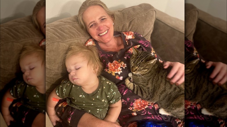 Christine Brown pose avec son petit-fils et son chat