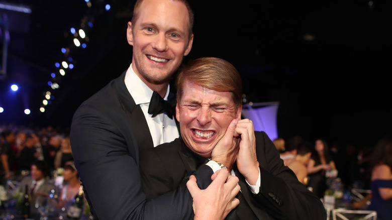 Jack McBrayer et Alexander Skarsgård s'étreignent et rient 