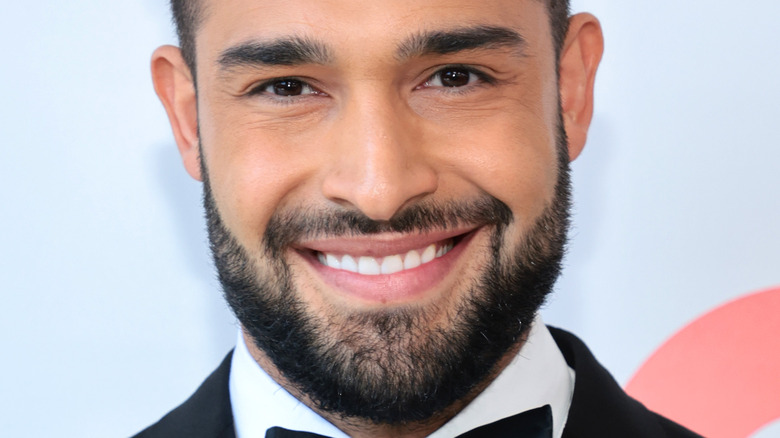 Sam Asghari sourit en smoking