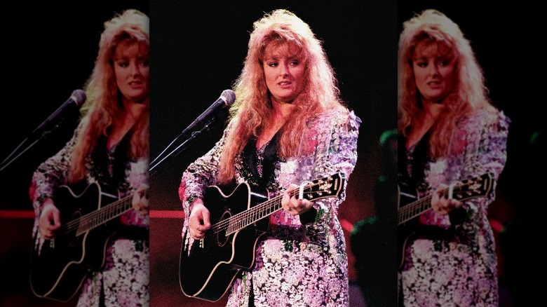 Wynonna Judd avec une frange jouant de la guitare