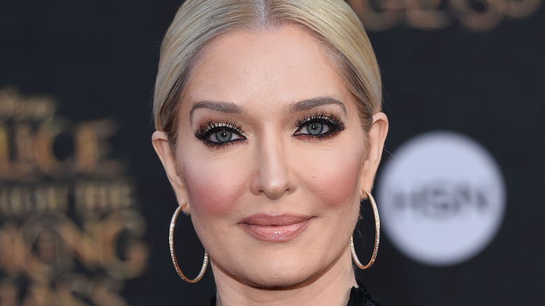 Erika Jayne cheveux lissés en arrière avec des boucles d'oreilles