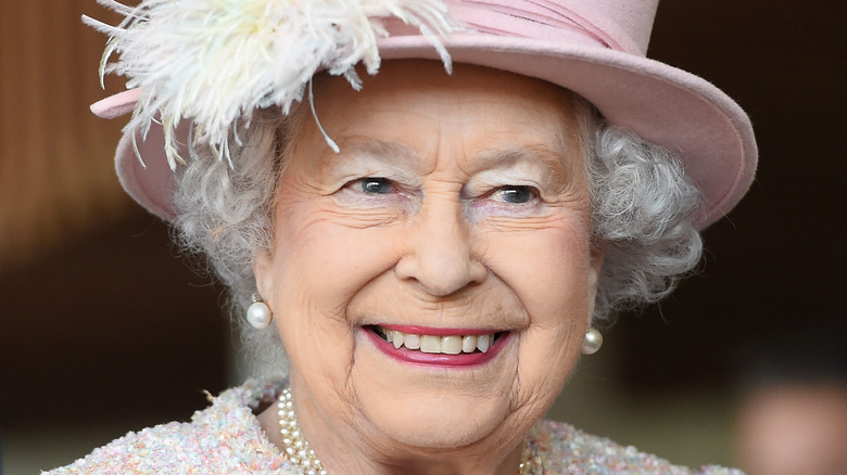 La reine Elizabeth II souriant dans un chapeau 