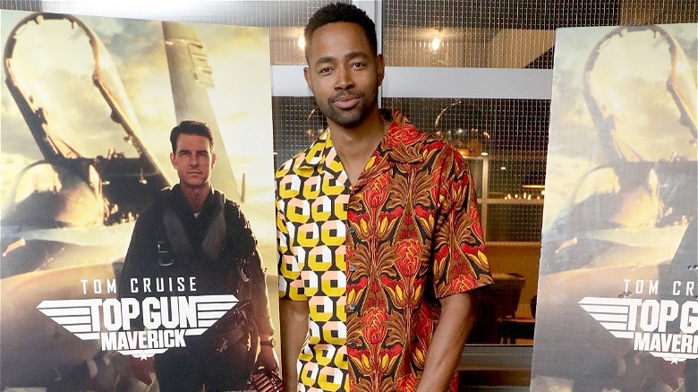 Jay Ellis pose avec les affiches de Top Gun: Maverick