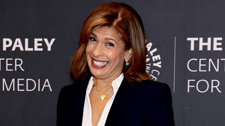 Hoda Kotb sourit dans un blazer noir et un chemisier blanc