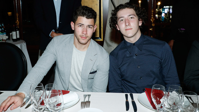 Nick Jonas et Frankie Jonas sont assis ensemble lors d'un événement