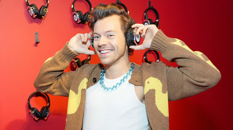 Harry Styles souriant avec des écouteurs