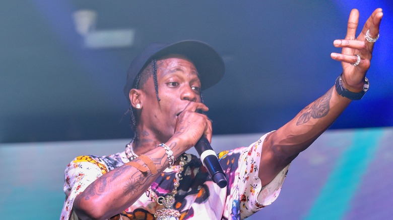 Travis Scott rappe le microphone bras gauche levé