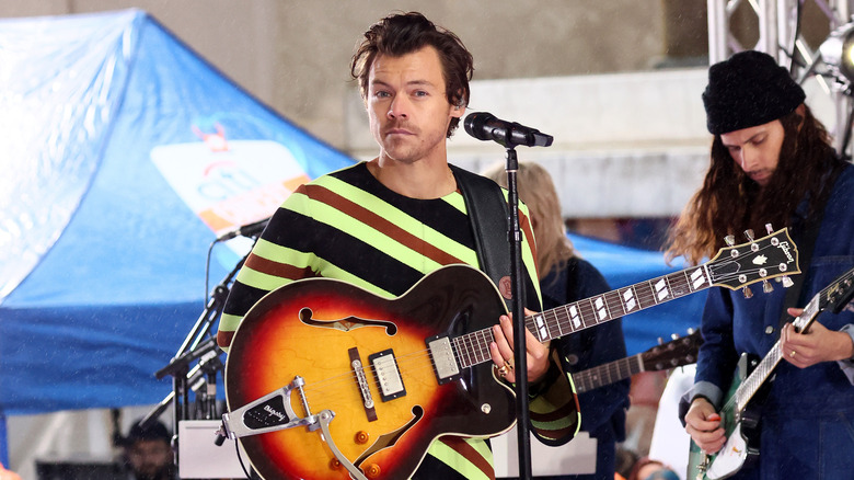 Harry Styles sur scène avec une guitare