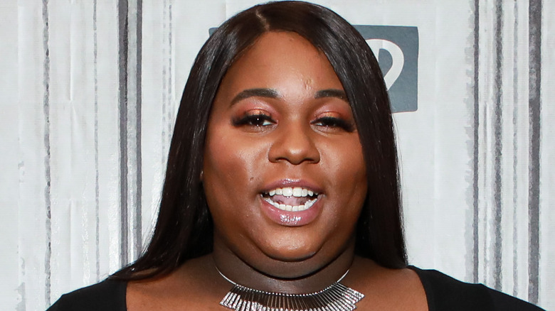 Alex Newell souriant à l'événement