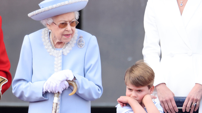 La reine Elizabeth en bleu avec son petit-fils renfrogné