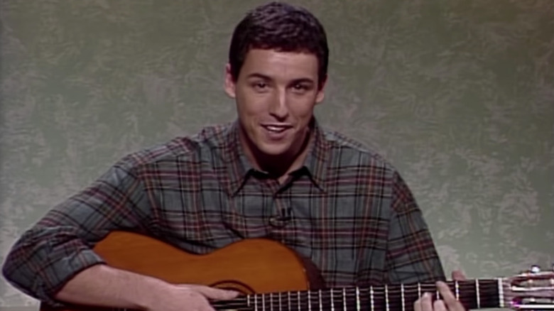 Adam Sandler tenant une guitare sur SNL en 1992