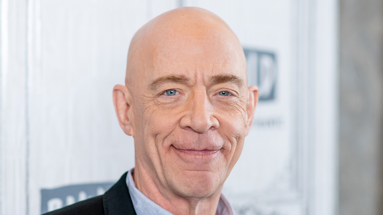 JK Simmons souriant avec la tête rasée 