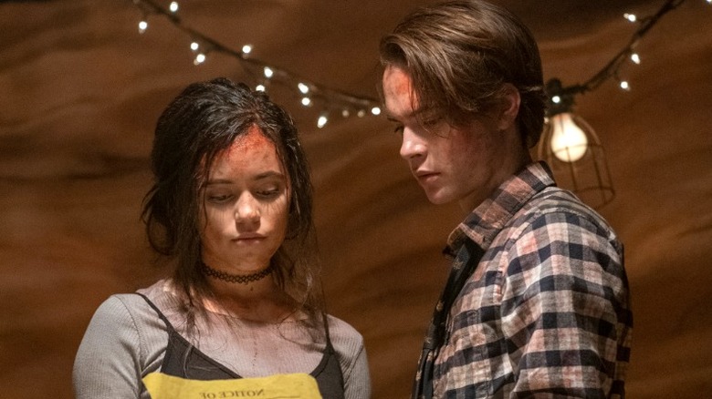 Jenna Ortega et Judah Lewis avec du sang sur le visage dans un film d'horreur