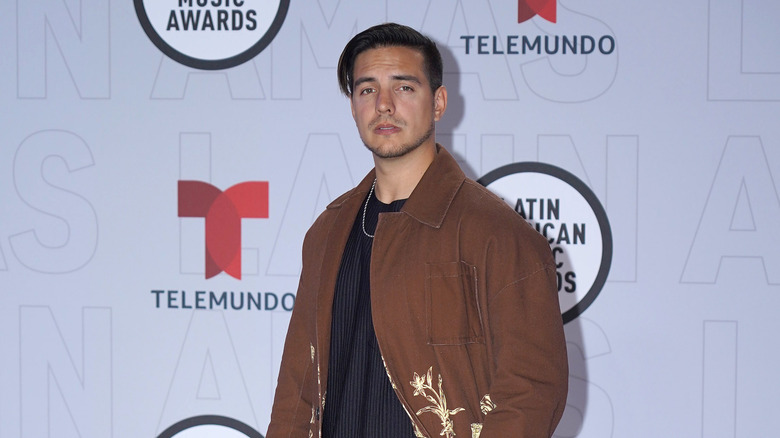 Vadhir Derbez posant sur le tapis rouge en veste marron