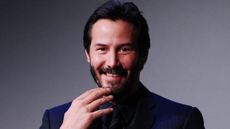 Keanu Reeves porte une main à sa bouche