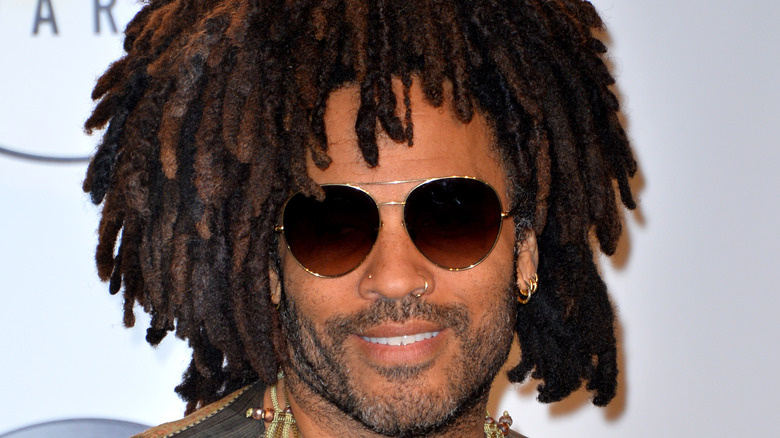 Lenny Kravitz souriant avec des lunettes de soleil