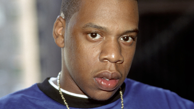 Jay-Z portant une chemise bleue et une chaîne