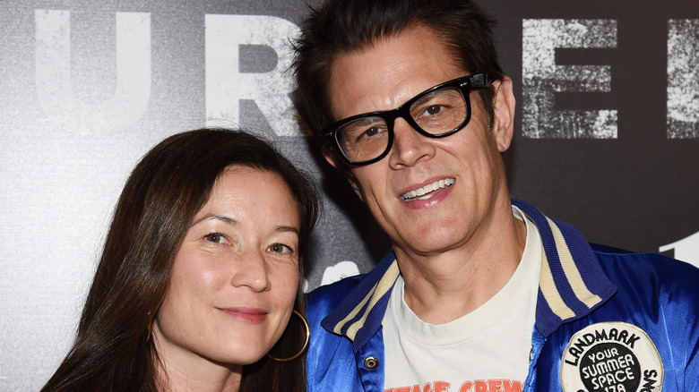 Naomi Nelson souriant Johnny Knoxville lunettes à monture noire se penchant vers