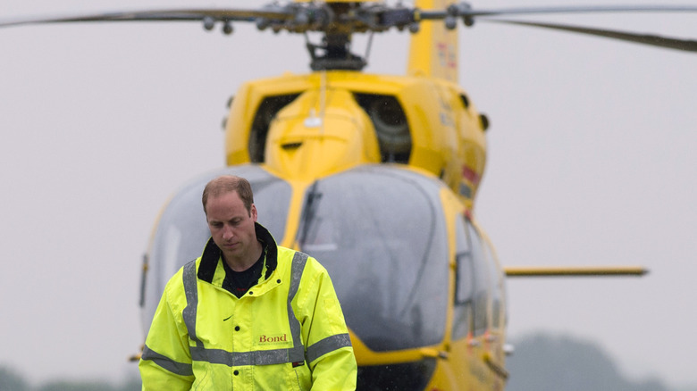 Le prince William marche devant son hélicoptère 