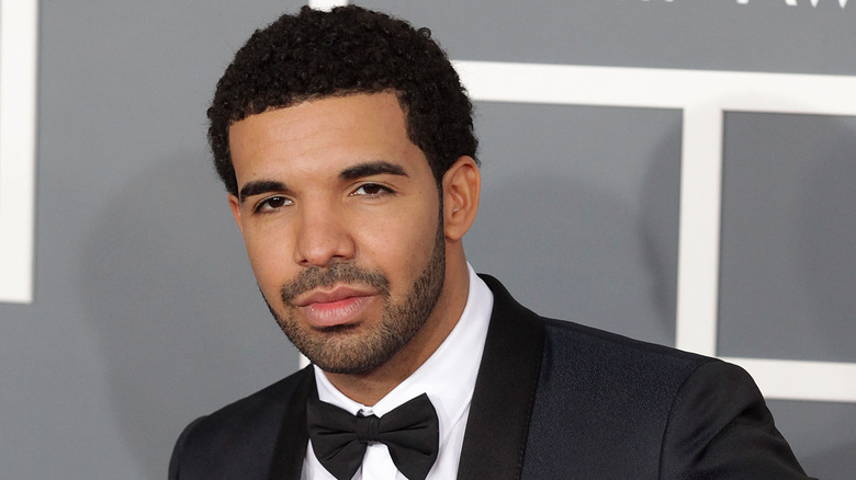 Drake souriant cheveux courts barbe coupée