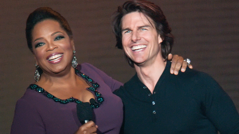 Oprah Winfrey et Tom Cruise lors d'un événement, souriant