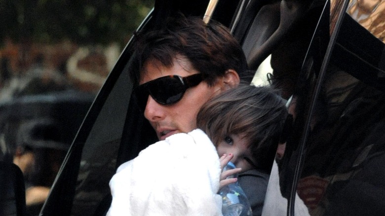 Tom Cruise tenant Suri, la sortant de la voiture