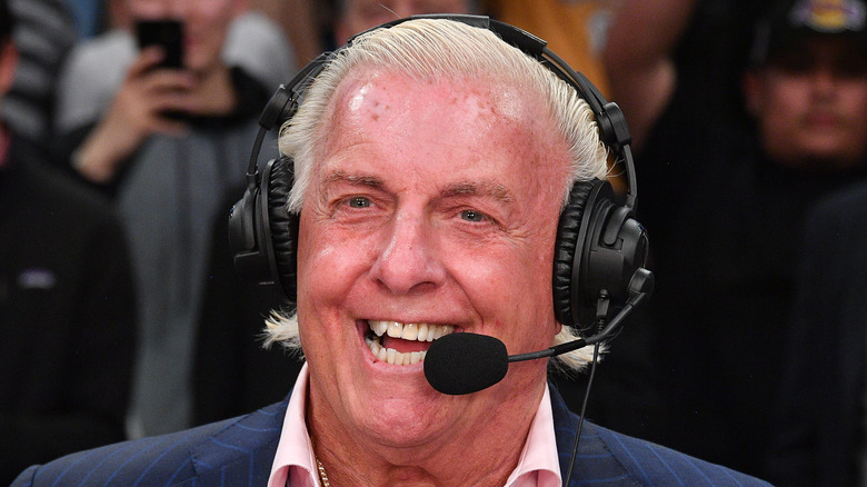 Ric Flair lors d'un événement, parlant avec un casque micro