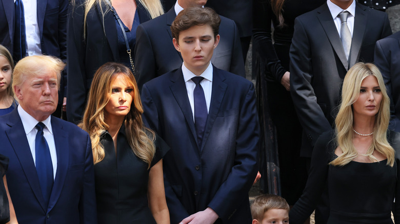 Barron Trump debout devant sa mère Melania et son père Donald Trump