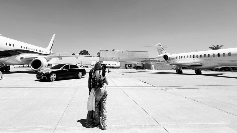 Kylie Jenner et Travis Scott debout devant des jets privés