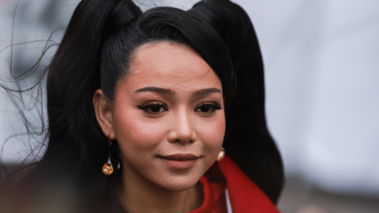 Bella Poarch pose sur le tapis rouge dans une veste rouge