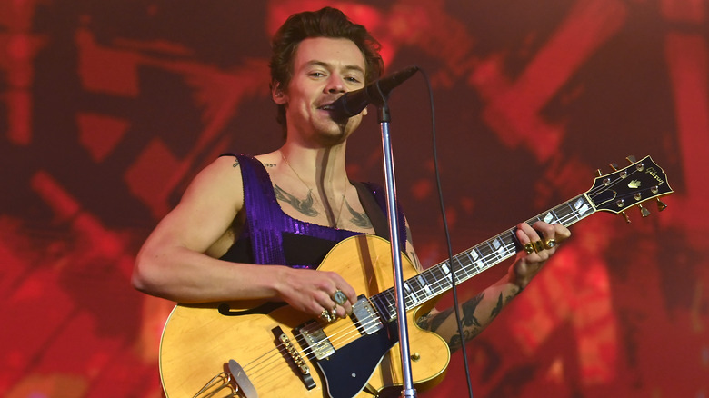 Harry Styles sur scène avec une guitare