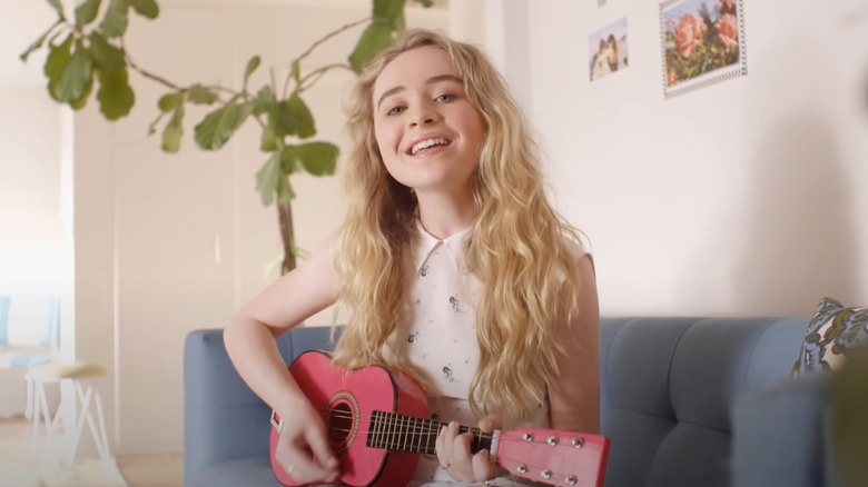 Sabrina Carpenter jouant du ukulélé rose