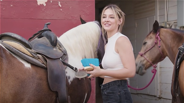 Madelyn Cline brosse les chevaux