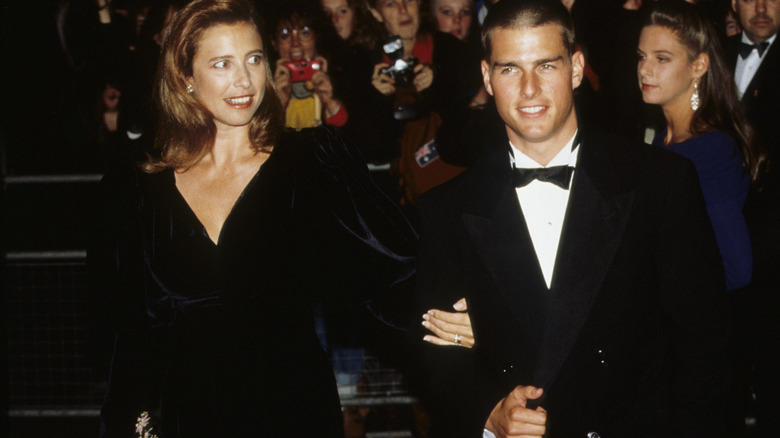 Mimi Rogers tient le bras de Tom Cruise en 1989