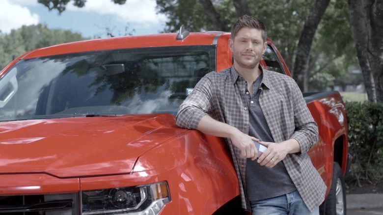 Jensen Ackles appuyé contre une voiture, posant