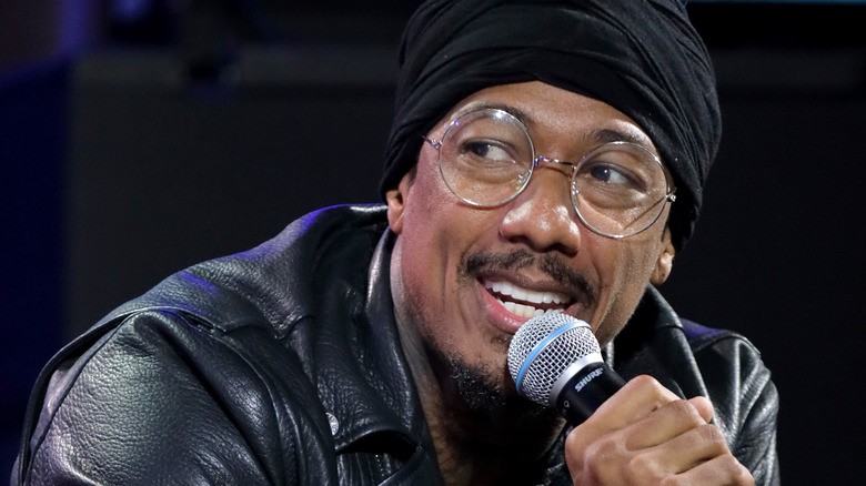 Nick Cannon porte des lunettes et une veste en cuir