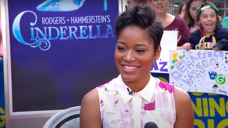 Keke Palmer devant une affiche de Cendrillon, souriant