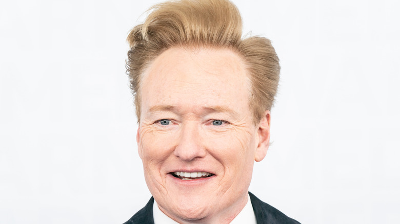 Conan O'Brien se tient devant un fond blanc