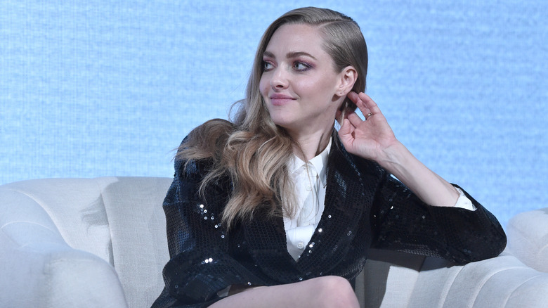 Amanda Seyfried assise sur un canapé