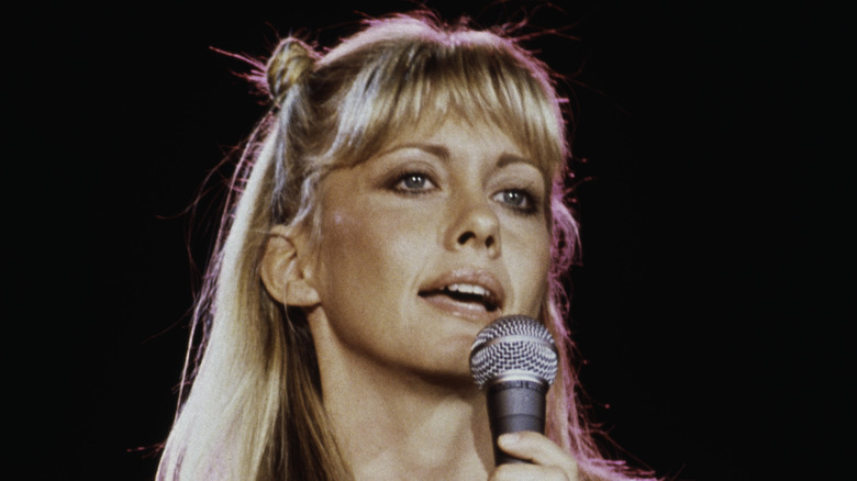 Olivia Newton-John chante dans le micro