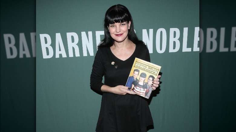 Pauley Perrette tenant un livre de cuisine