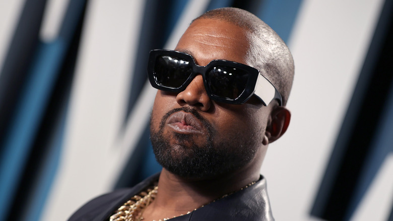 Kanye West lors d'un événement, portant des lunettes de soleil