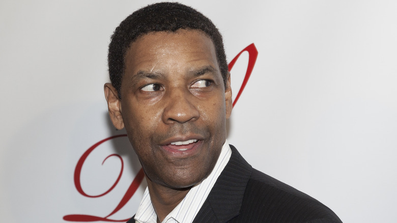 Denzel Washington regarde à gauche et sourit