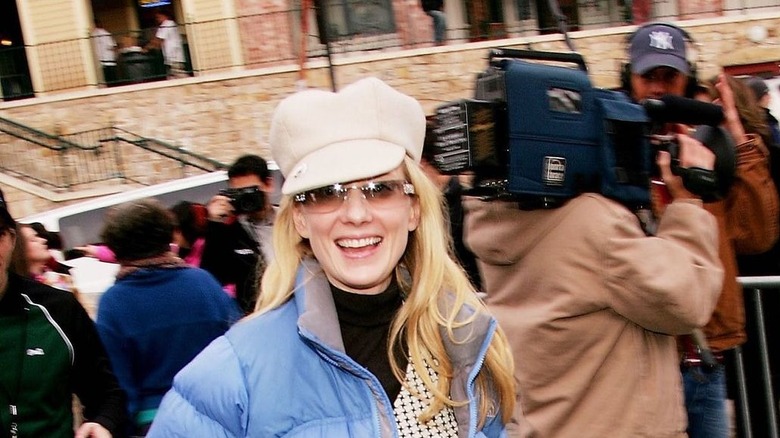 Anne Heche souriante avec un manteau