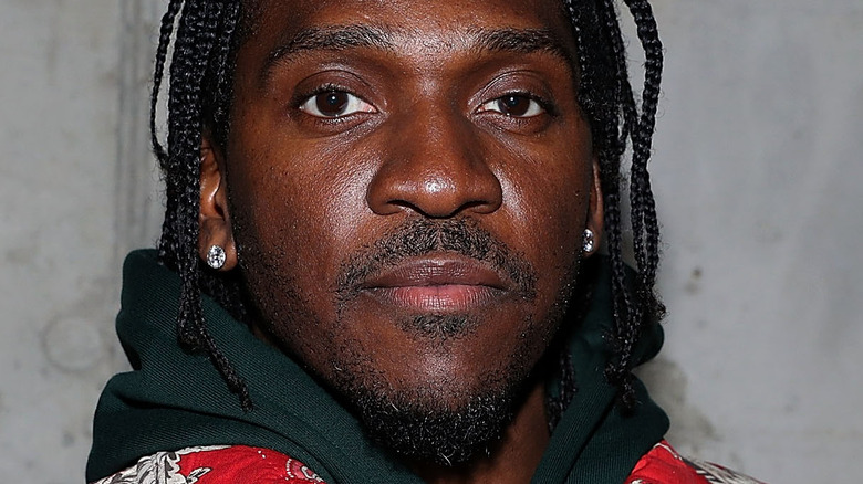 Pusha T portant une veste rouge, posant