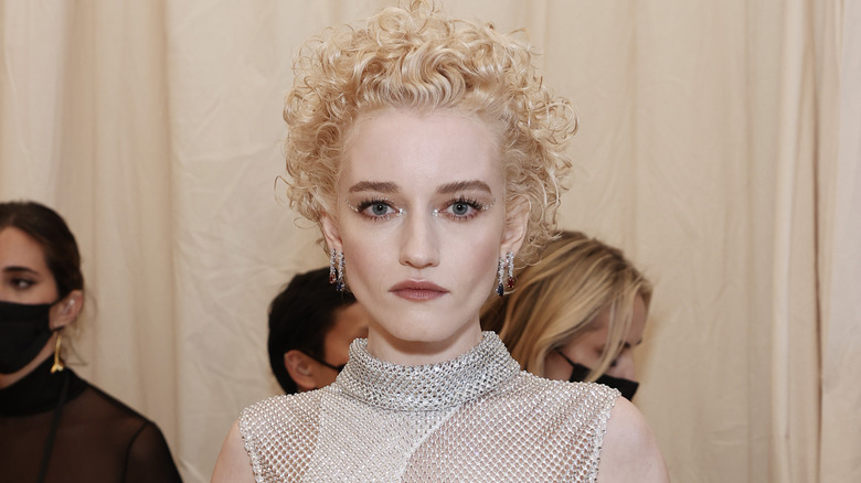 Julia Garner pose dans une robe argentée