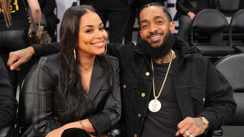 Lauren London et Nipsey Hussle souriant au match de basket