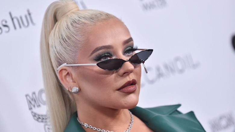 Christina Aguilera portant une queue de cheval serrée et de minuscules lunettes de soleil