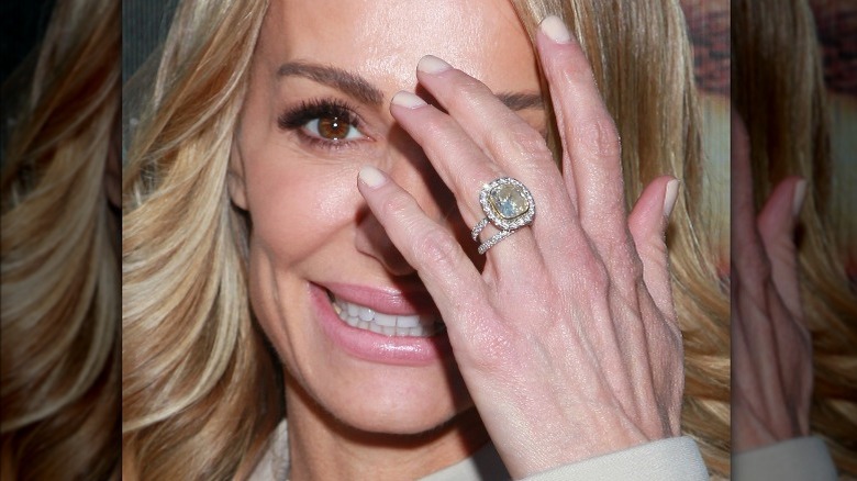 Taylor Armstrong avec une bague, couvrant son visage, souriant