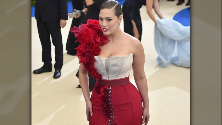 Ashley Graham posant dans une robe rouge et blanche du Met Gala